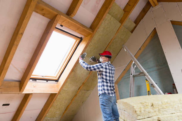 Man installing thermal roof insulation layer using mineral wool panels